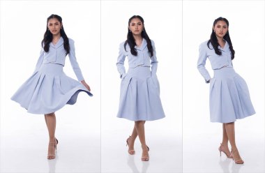 20 'li yaşlarda, Asyalı bir kadının tam boy fotoğrafı. Siyah saç, iş pastel mavi etek, etek, elbise ve ayakkabı giyiyor. Kadın duruşu ve kendine güveni ifade eden mutlu gülümseme beyaz arka planda izole edilmiş.