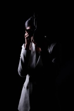 Asyalı Kadın Fotoğrafçı, kamerayı dış ışık noktasıyla tut, hedefi çek, gri takım elbise giy. Stüdyo aydınlatma siyah arka plan izole düşük anahtar maruz, muhabir fotoğraf çekmek ünlü