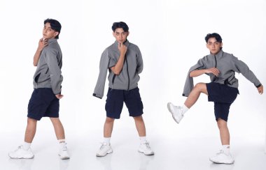 20 'li yaşlarda, Asyalı, bronz tenli, siyah tişörtlü, pantolonlu, spor ayakkabılı, izole bir adam. Yakışıklı erkek modern dans eder. Eğlenceli hisseder. Beyaz arka plan stüdyosuna eğilir.