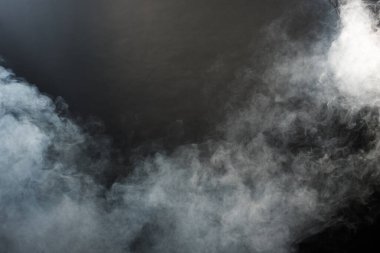 Siyah Arkaplanda Yoğun Tüy Tüten Duman ve Sis, Soyut Duman Bulutları, Odakta Bulanık Hareket. Kuru buz sineğinden duman üfleme ve havada kanat çırpma dokuyu etkiler.