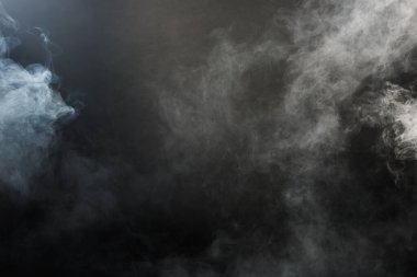 Siyah Arkaplanda Yoğun Tüy Tüten Duman ve Sis, Soyut Duman Bulutları, Odakta Bulanık Hareket. Kuru buz sineğinden duman üfleme ve havada kanat çırpma dokuyu etkiler.