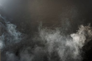 Siyah Arkaplanda Yoğun Tüy Tüten Duman ve Sis, Soyut Duman Bulutları, Odakta Bulanık Hareket. Kuru buz sineğinden duman üfleme ve havada kanat çırpma dokuyu etkiler.