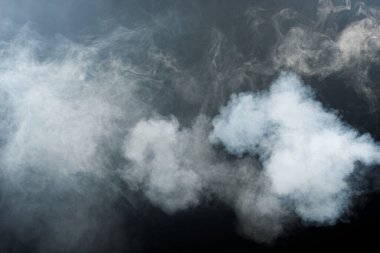 Siyah Arkaplanda Yoğun Tüy Tüten Duman ve Sis, Soyut Duman Bulutları, Odakta Bulanık Hareket. Kuru buz sineğinden duman üfleme ve havada kanat çırpma dokuyu etkiler.