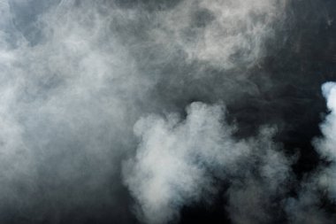 Siyah Arkaplanda Yoğun Tüy Tüten Duman ve Sis, Soyut Duman Bulutları, Odakta Bulanık Hareket. Kuru buz sineğinden duman üfleme ve havada kanat çırpma dokuyu etkiler.