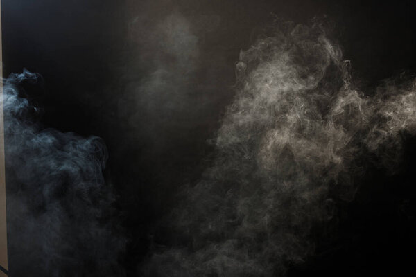 Dense Fluffy Puffs of White Smoke and Fog on Black Background, Abstract Smoke Clouds, Movement Blurred out of focus. Smoking blows from machine dry ice fly and fluttering in Air, effect texture