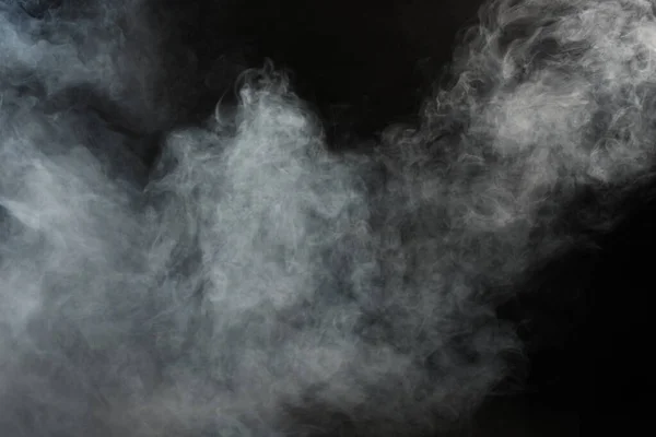 Dense Fluffy Puffs of White Smoke and Fog on Black Background, Abstract Smoke Clouds, Movement Blurred out of focus. Smoking blows from machine dry ice fly and fluttering in Air, effect texture