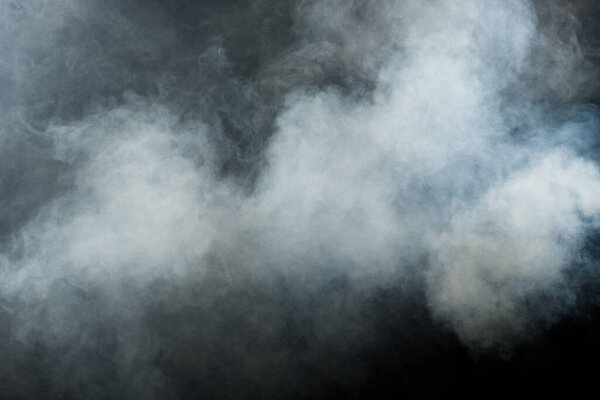 Пушистые пушистые пятна белого дыма и тумана на черном фоне, абстрактные облака дыма, затуманенное движение. Курение удары из машины сухой лед мухи и трепетать в воздухе, эффект текстуры