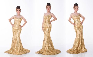 20 'li yaşlardaki Asyalı güzel kadın gala yemeği için altın uzun balo elbisesi giyer ve buluşmayı kutlar. Genç zeki kadın mutlu bir gülümseme hissederek ayakta duruyor. Beyaz arkaplan izole