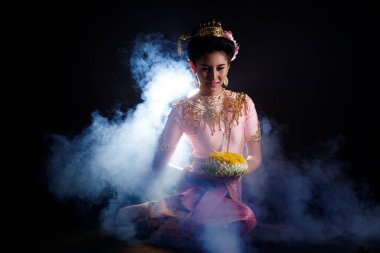 Tayland Geleneksel Kostümü Loykrathong Elbisesi veya Güneydoğu Asya Altın Elbisesi Süslü Asyalı Kadın Elbisesi Loy Krathong Yüzen Festivali 'ne siyah arka planda gülümsediğini ifade ediyor