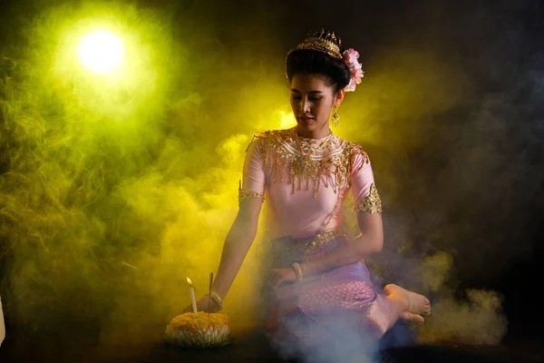 Loykrathongタイの伝統衣装や東南アジアの金のドレス装飾スタンド付きアジアの女性のドレス黒を背景にロイKrathongフローティングフェスティバルのための幸せな笑顔を表現 — ストック写真