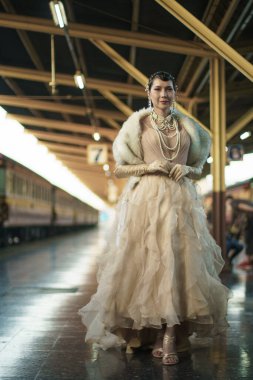 Güzel Gatsby kadınının antika portresi etrafına bak, tam dönüş, duygu ifadesi 20 'li yaşlarda halk tren istasyonunda romantik bir moda tarzı, Gatsby eski moda konsepti