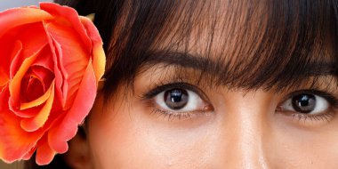 Asya Hintli Arap karışık ırk 20 'li yaşlardaki kadınlar, moda, kısa saçlı, uzun makyajlı, mutlu bir gülümseme sergiliyor. Kadın yüzü, sarı bej arkaplanda yakın çekim yapıyor. 