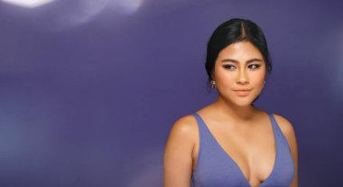 Asyalı 20 'li yaşlarda tombul bir kadın mor renkli spor sutyen giyer ya da mor arka planda çok Peri tarzı moda olur. Yarı vücut, siyah saç ekspresi. Stüdyo ışıklarında yüzünde güçlü bir gülümseme hissediyor.
