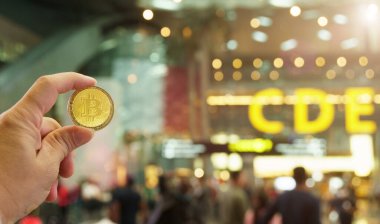 Gezici şifreleme cüzdanı uygulamasındaki Bitcoins Yeni Sanal Para Konsepti seyahat tatili sırasında seyahat parası satın alabiliyor. Altın Bitcoin havaalanı bilet ödeme kasiyerinde turistin elinde, kopyalama alanı