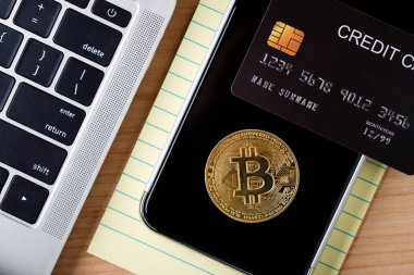 Bitcoin standart BTC kripto para birimi dizüstü bilgisayarda, Üst görünüm ahşap masa üzerinde hesap makinesi ve cep telefonu, kağıt not, kredi kartı ile maket