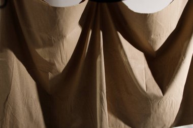 Duvara asılı tuval kumaş, güneş ışığı gölgesi ile beyaz renkte krem dokuma detaylarıyla birlikte. Boş alan arkaplanı için reklam modeli