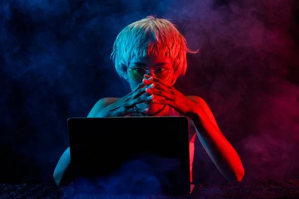 ブロンドヘア女性は利益のためにラップトップで暗号通貨を取引し コンピュータノートブックで楽しいオンラインゲームをプレイします 女性のエクスプレス感ストレス狂気のうつ病の損失 暗い煙背景コピースペース — ストック写真