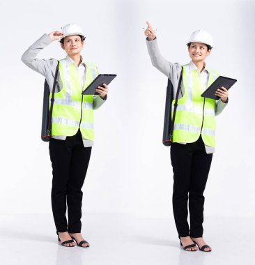 20 'li yaşlarda, genç Mix Race mühendisi, mimar kadın, boş havayı işaret ediyor, güvenlik için geniş bir tablet giyiyor. Ofis kadını beyaz arka planda mutlu bir gülümseme hisseder.