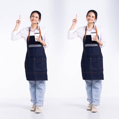 20 'li yaşlarda, barista dükkanı işleten genç bir bayan, havayı işaret ediyor, önlüklü kahve fincanı giyiyor. Ofis kadını beyaz arka planda mutlu bir gülümseme hisseder.