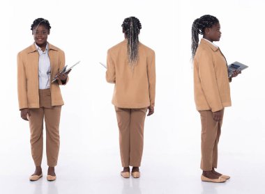 20 'li yaşlarda, Afro-Amerikan kadın muhasebeci, 360' lı yaşlarda, ön tarafı arkaya dönük, resmi spor pantolon ve ayakkabı giyiyor. Ofisteki kadın hesap makinesini beyaz arka planda tek başına taşıyor.