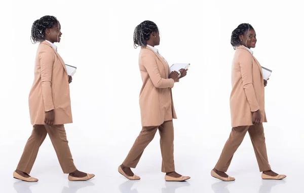 Full length 20s young African American Woman teacher student lawyer, walking forward left right, wear formal blazer pants and shoes. Office female carry books folders over white background isolated