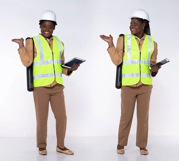 Full length 20s young African American Woman Architecture Client Engineer, showing empty palm hand, wear formal blazer pants and shoes. Contractor female carry internet tablet over white background isolated