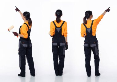 20 'li yaşlarda, genç Asyalı kadın dekorasyon ressamı, parmağını havaya kaldırmış, turuncu tulum üniformalı eldivenler giyiyor. Gülümse, mutlu kadın. Beyaz arka planda boya fırçası tut.