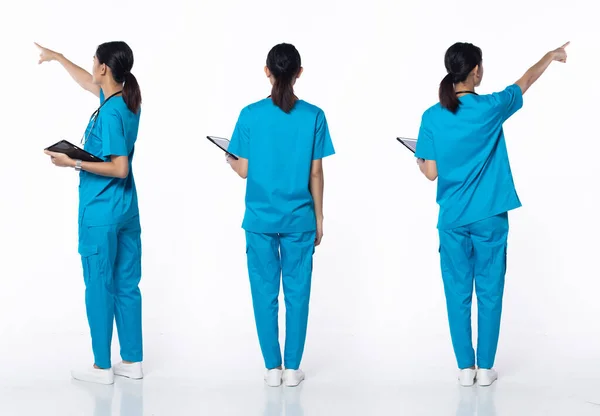 全长20多岁的年轻亚洲妇女诊所护士 指尖向上在空气中 穿着蓝色连衣裙裤子鞋听诊器 微笑医院的女性患者在白色背景下保持着病历隔离 — 图库照片