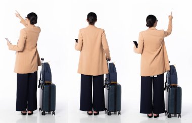 30 'lu yaşlarda, Asyalı, hamile bir kadın iş gezisi, havaya parmak sallamak, resmi spor ceket ayakkabıları giymek. Gülümseyen ofis kadını sırt çantasındaki telefonu beyaz arka planda tek başına taşıyor.