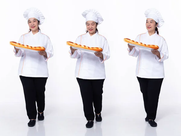 Full length 40s 50s Asian Senior Woman Cooking Chef, walking bread forward left right, wear white formal uniform pants. Smile restaurant female stands feels smile happy over white background isolated