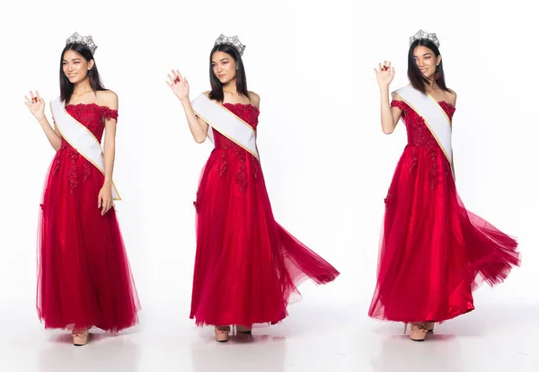 Full length of Miss Beauty Pageant Contest wear red evening sequin gown with diamond crown sash, Asian female stand express feeling happy smile over white background isolated