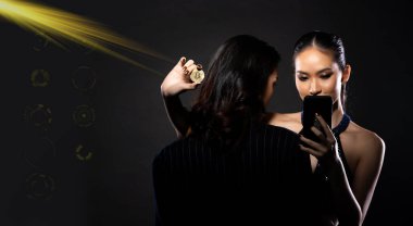 Young Beautiful Woman hold Bitcoin Cryptocurrency and transfer to her wallet by internet phone. Mistress manipulate and cheat rich sugar daddy man for digital future money