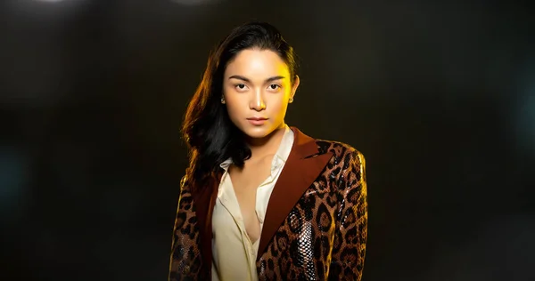 Half body portrait of Asian beautiful woman wear formal blazer, unisex handsome man look make up style. Young female express feeling smile strong over black background isolated copy space