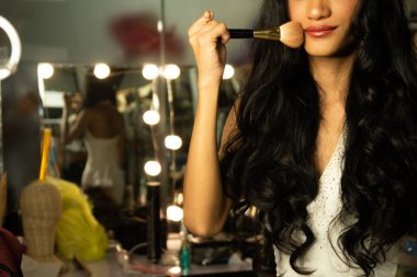 Half body disable person without fingers thumb hand of young adult woman using cosmetic brush lipstick at make up mirror desk. Female smile cheerful in white evening gown ball dress long hair