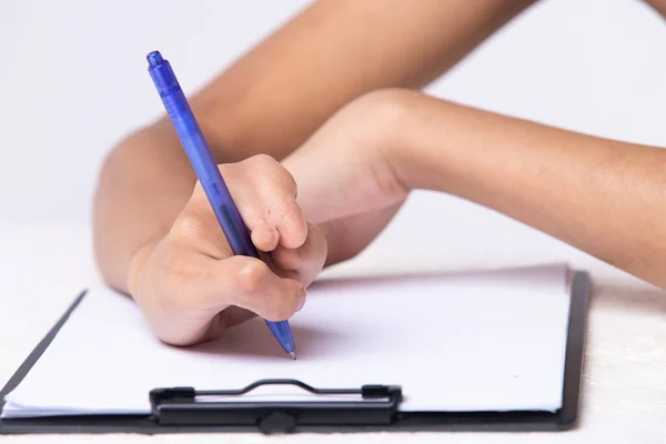 Disabled person hand without fingers since childhood brith, using pen to write word sentence on paper note. Woman use short fingers to hold pen as normal people, white background isolated copy space