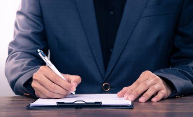 Person Signing Approval document, certificate, legal agreement in office by pen and stamp hand. Authority apply law to do contract paperwork form by public notary clerk or official lawyer, copy space