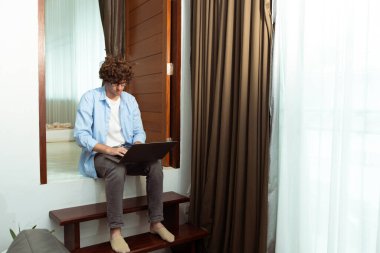 Young Caucasian Man work from home on laptop and connect online to office indoor for remote internet workplace. Young Adult male  is freelance work smart on notebook anywhere house, copy space