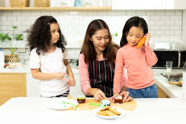 Group of Diverse Family, Asian and Arab Preschool African Arab kid person make Cake cooking in kitchen, Mother prepare decoration pretty with fun educate on snack. Cream mess all over face, copy space