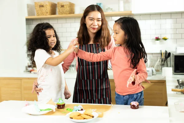 Group of Diverse Family, Asian and Arab Preschool African Arab kid person make Cake cooking in kitchen, Mother prepare decoration pretty with fun educate on snack. Cream mess all over face, copy space