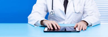 Tıbbi ve sağlık hizmetleri için internet veri ağı taraması kavramı. Doktor arama internet barında arama yapmak tablet arkaplanı tutmak mavi ofis odasında, boşluğu kopyala