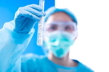 Laboratuar asistanı üniforması ve maske eldivenleriyle deney tüpü ve bilim laboratuvarı araştırma numunesi tutarken, grafik büyüme geliri olarak biyoloji kimyasalı üzerindeki gelişmeyi analiz ederken yatırım gelirini artırıyor, yer kopyalıyor.