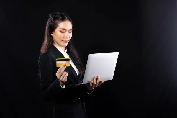 Business woman hold gold credit card and shopping online with internet financial banking payment when purchasing. Technology help person shopping at home in e-commerce store on mobile phone or laptop