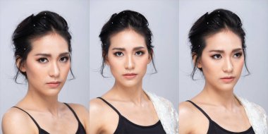 20 'li yaşlardaki Asyalı kadınların yüz hatları çok güzeldir. Siyah, uzun düz saçlı bir kadın mutlu bir gülümseme hissediyor. Moda modası, gri arka planda izole edilmiş pozlar veriyor.