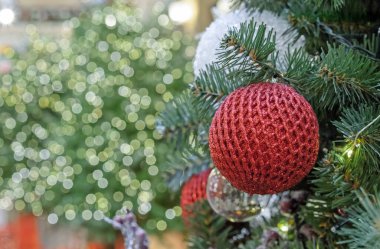 Bokeh arka planında ağ süsü olan kırmızı parlak bir Noel topu..