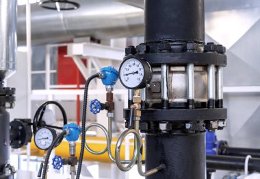 Gaz kazan dairesinde basınç göstergesiyle kapaklı kontrol vanası..