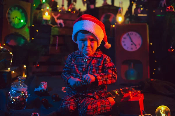 Noel süsleri. Hayal kırıklığına uğramış bir çocuk yerde oturuyor..