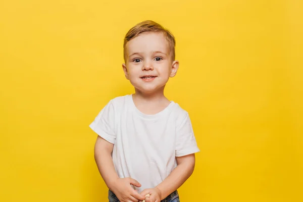 Niño sonriente sobre un fondo amarillo. Copiar espacio. — Foto de Stock
