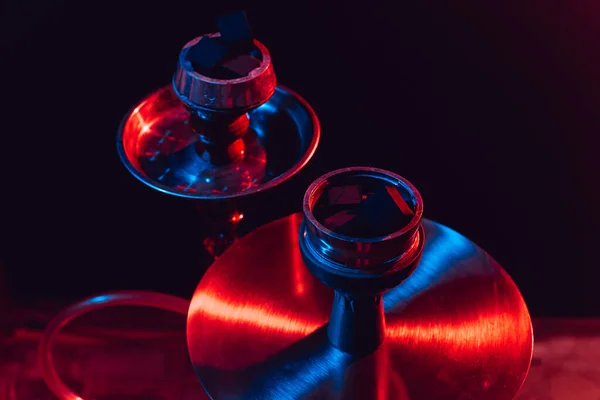 Hookah bowl, shisha and coals close-up on a black background with colored lighting — Stock Photo, Image