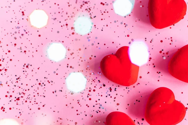 Inimi roșii pe fundal roz cu confetti. Șablon Ziua Îndrăgostiților cu spațiu de copiere — Fotografie, imagine de stoc