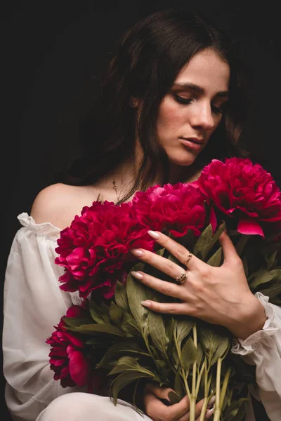 赤い牡丹の花束を手にした若い官能的な女性の肖像画 — ストック写真